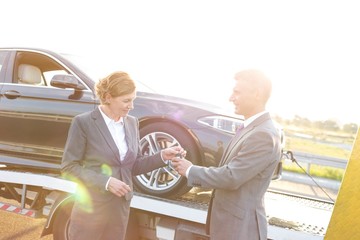 Wall Mural - Businesswoman giving her keys to tow truck driver