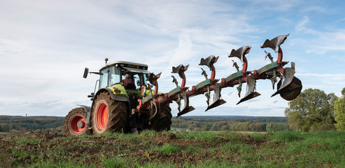 Poster - tractor and plow under blue sky on field in luxembourgh