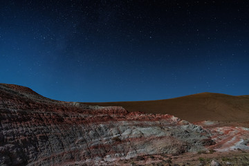 Amazing striped red mountains on a moon night