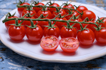 Small ripe red sweet cherry tomatoes on twig