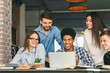 © Prostock-studio - Happy classmates discussing project at library, using laptop