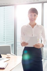 Businesswoman standing while holding document in office