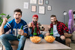 Photo of guys pointing finger and drinking beer while watching match