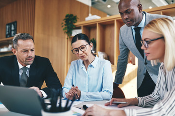 Diverse businesspeople going over paperwork together during an o