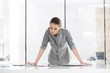 © MDBPIXS - Businesswoman standing reading while analyzing documents in office