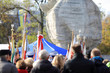 Tłumy ludzi ze sztandarami i flagami przed pomnikiem w Opolu.