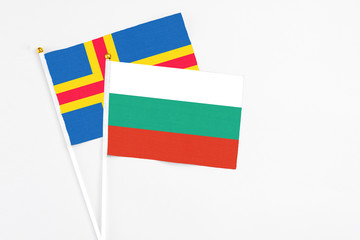 Bulgaria and Aland Islands stick flags on white background. High quality fabric, miniature national flag. Peaceful global concept.White floor for copy space.