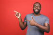 Afro american man over isolated red background amazed and smiling to the camera while presenting with hand and pointing with finger.