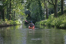 A Person Kayaking Along A Canal In The Countryside Of Utrecht