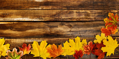 Wall Mural - autumn maple leaves on top view wooden boards. horizontal long frame with corner color leafage on bo