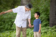 © Blue Jean Images - Happy Chinese grandfather and grandson holding hands in park