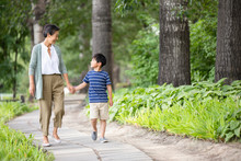 Happy Chinese Grandmother And Grandson Walking In Park