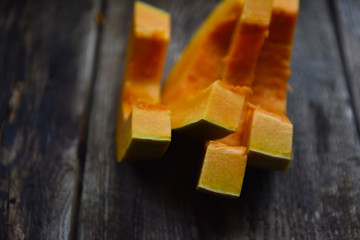 ripe orange pumpkin sliced on a wooden table