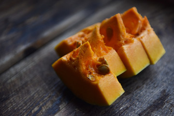 Wall Mural - ripe orange pumpkin sliced on a wooden table