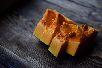 Wall Mural - ripe orange pumpkin sliced on a wooden table