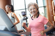 © Blue Jean Images - Senior Chinese woman running with wireless headphone at gym