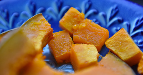 Wall Mural - baked orange pumpkin sliced on a wooden table