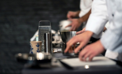 Team of professional chefs preparing food in a commercial kitchen. Cooks in the production process of system catering. An inside view of a pro catering kitchen.