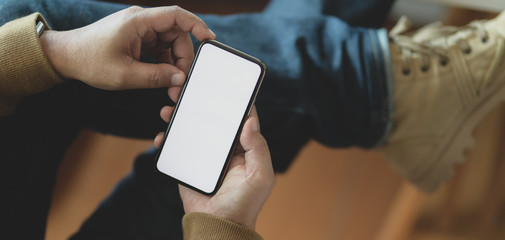 Cropped shot of young man holding blank screen smartphone