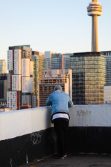 Wall Mural - Impressive view of city, man standing looking over the city, man surrounded by skyscrapers, man with view of CN tower