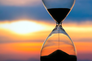 hourglass on the background of a sunset. the value of time in life. an eternity..