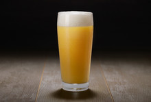 A Glass Of India Pale Ale, Hazy Unfiltered Juicy Draft Beer On Wooden Surface And Black Background