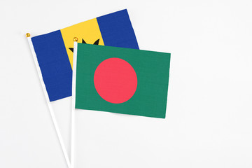 Bangladesh and Barbados stick flags on white background. High quality fabric, miniature national flag. Peaceful global concept.White floor for copy space.