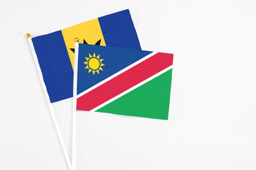 Namibia and Barbados stick flags on white background. High quality fabric, miniature national flag. Peaceful global concept.White floor for copy space.