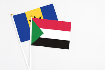 Sudan and Barbados stick flags on white background. High quality fabric, miniature national flag. Peaceful global concept.White floor for copy space.