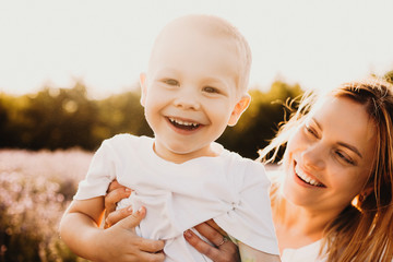 Wall Mural - portrait of a cute little boy laughing while looking at camera while his mother is playing with him 