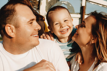 Wall Mural - close up portrait of a happy little kid looking at camera laughing while playing with his father and
