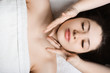 © Strelciuc - Upper view portrait of a beautiful woman having facial massage before doing mask in a wellness spa center.