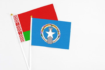 Northern Mariana Islands and Belarus stick flags on white background. High quality fabric, miniature national flag. Peaceful global concept.White floor for copy space.