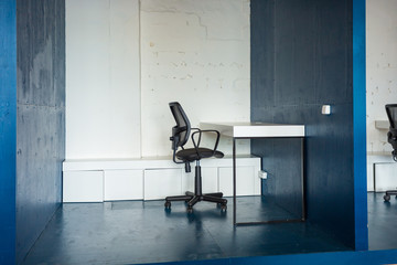 Wall Mural - Loft style office with white brick walls and concrete columns. There is a meeting area with a large white table with black chairs