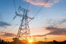 High-voltage Power Lines At Sunset Or Sunrise. High Voltage Electric Transmission Tower