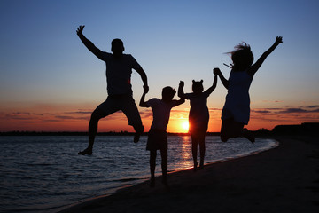 Poster - Silhouette of happy family on sea beach at sunset