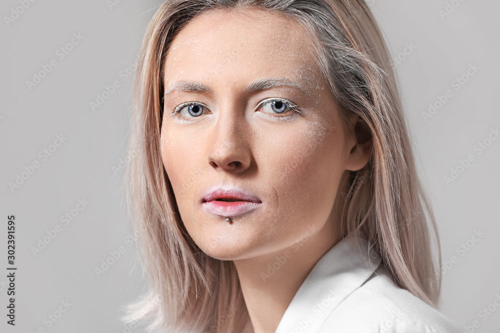 Beautiful woman with creative makeup on grey background