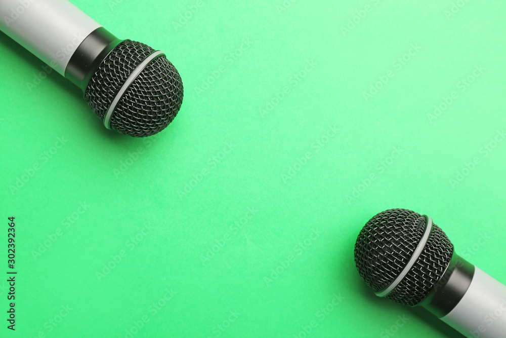 Modern microphones on color background