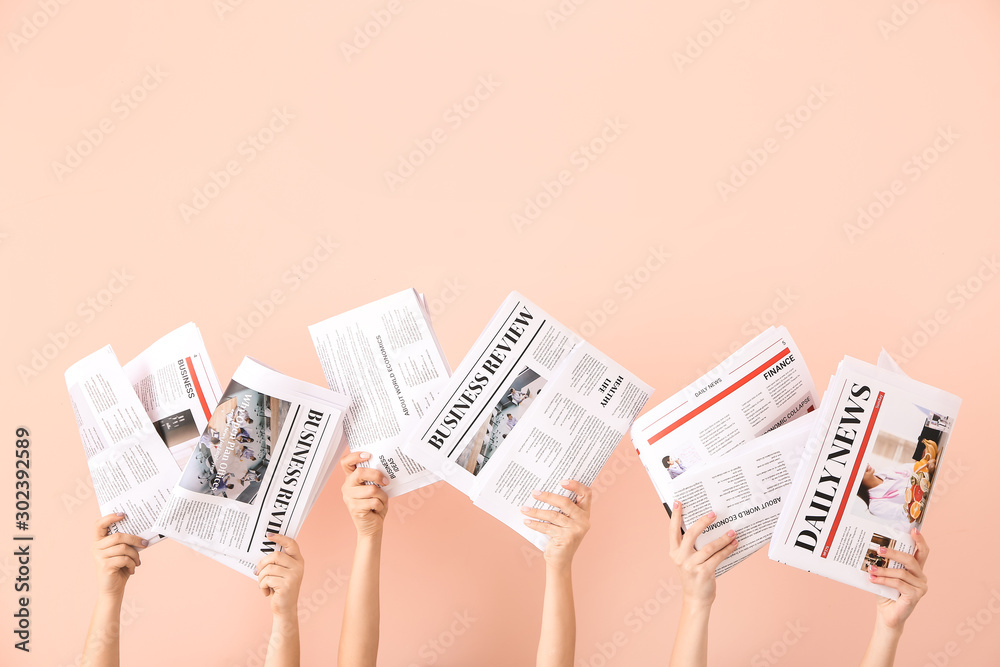 Female hands with newspapers on color background