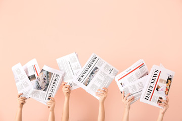 Wall Mural - Female hands with newspapers on color background