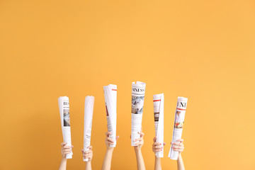 Poster - Female hands with newspapers on color background