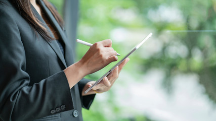 Fototapete - cropped view of businesswoman in suit using digital tablet.