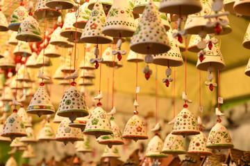 Wall Mural - Florence, ITALY - DECEMBER 2018: small decorated bells hanging from the roof at the Christmas market in front of the 'Basilica of Santa Croce'. Christmas