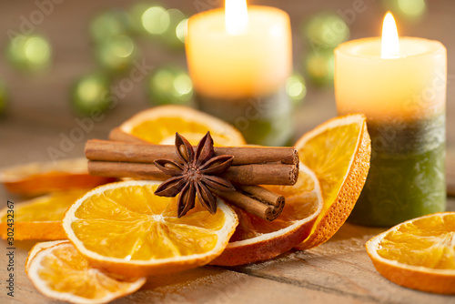 Photographie Christmas or advent decoration - candles with orange slices and spices on old wo