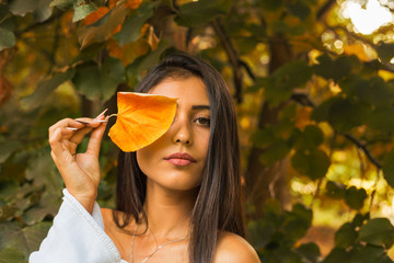 fall portrait of beauty woman holding fall leave