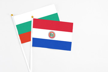 Paraguay and Bulgaria stick flags on white background. High quality fabric, miniature national flag. Peaceful global concept.White floor for copy space.
