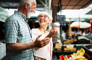 Portrait of beautiful elderly couple in market buing food