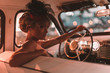 canvas print picture - Portrait of beautiful sexy fashion blond girl. Model with bright makeup and curly hairstyle in retro style hat sitting in old car. Attractive woman  rides around the night city