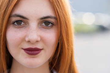 Wall Mural - Closeup face portrait of a girl with red hair and clear eyes.