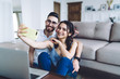 © BullRun - Positive fellows hugging in domicile and shooting selfie